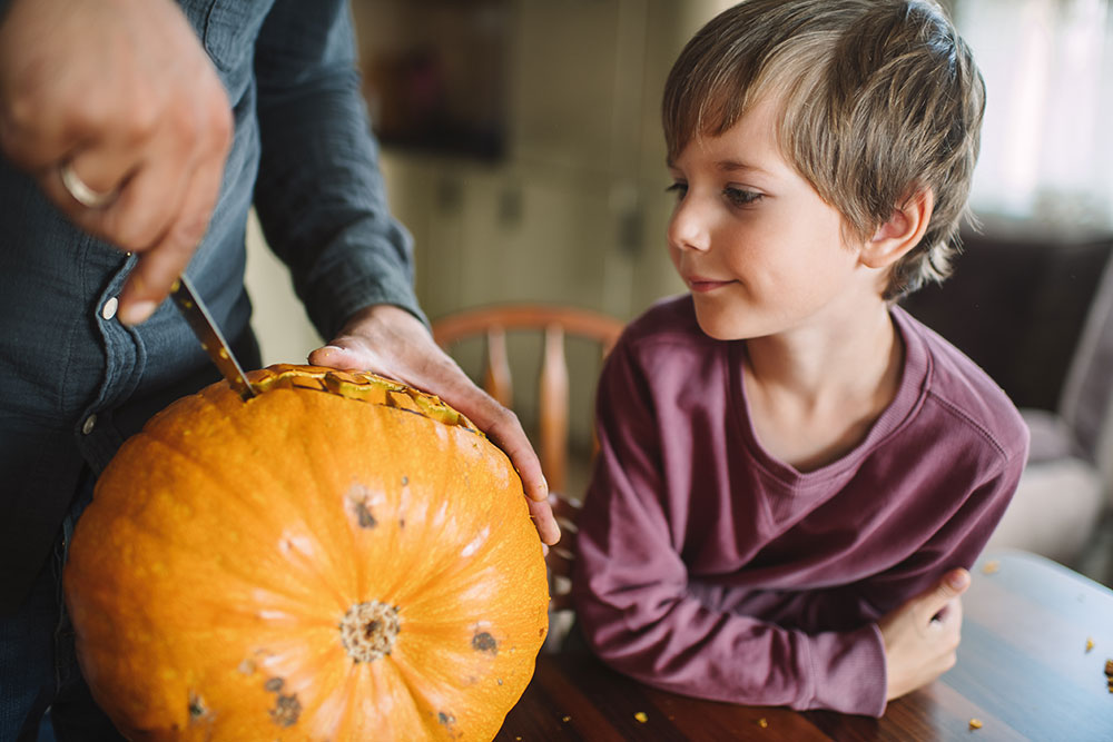 Halloween Safety - Child watching a pumpkin being carved