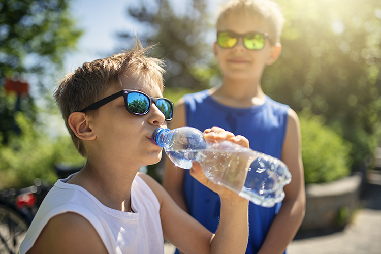 Young boy drinking a bottle of water