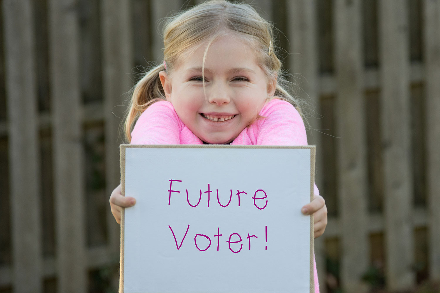 Child holding a "Future Voter!" sign