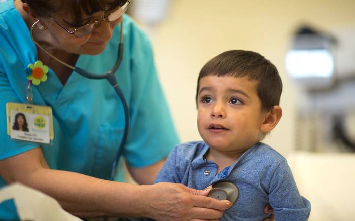 Child being evaluated by a stethoscope by a doctor