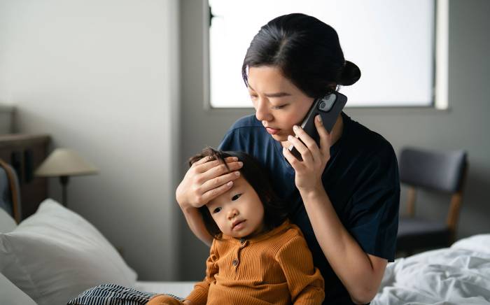 Mother holding child while talking on the phone